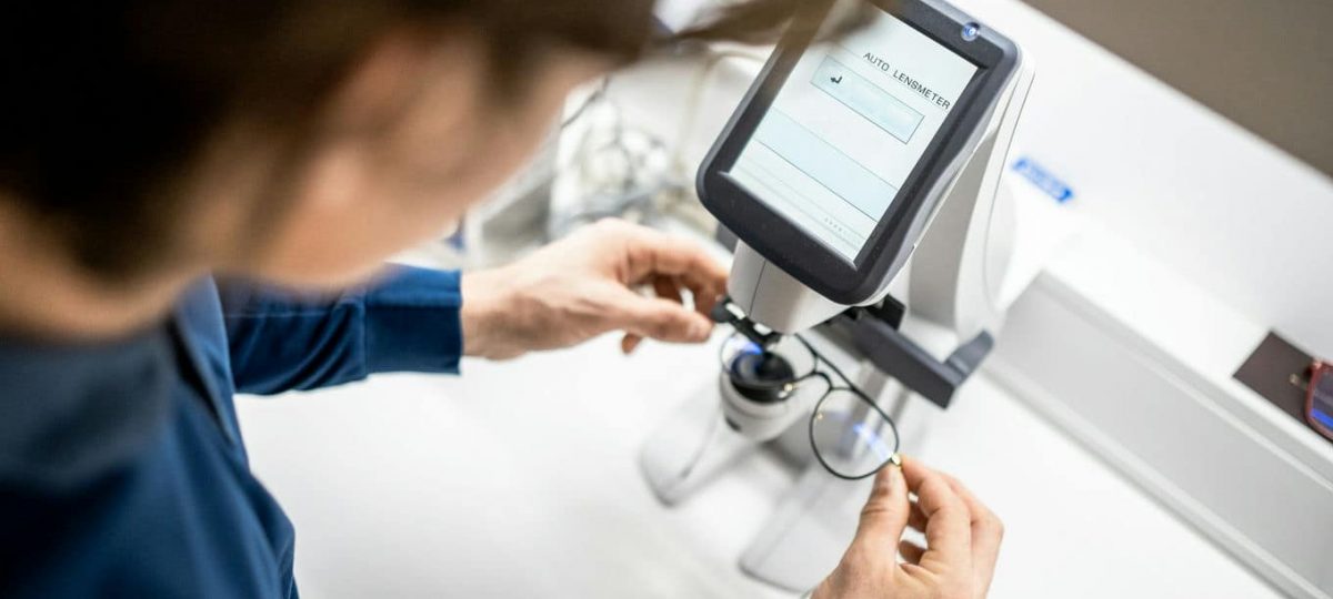 mężczyzna sprawdzający okulary na dioptromierzu